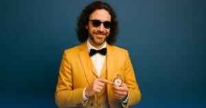 Uomo elegante sorride e indica un orologio da taschino – rappresentazione simbolica dei tempi per l’atto di benestare.