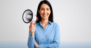 Donna sorridente con megafono in mano, simbolo di comunicazione istituzionale NoiPA che informa i dipendenti pubblici riguardo opportunità di credito agevolato